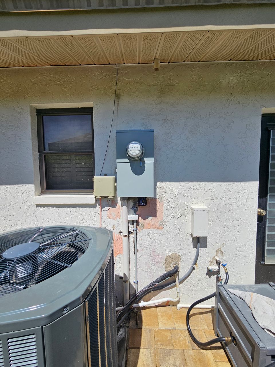 New gray meter can with a surge protector mounted below it and new conduit runs, after the upgrade