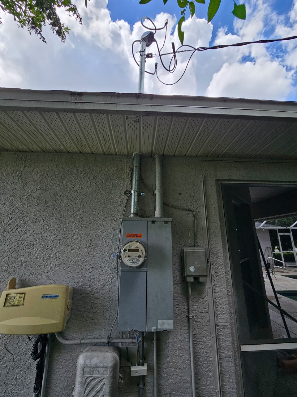 Straightened and secured electrical service riser with new meter can, DANGER HIGH VOLTAGE label and clean service drop after repair in Cape Coral