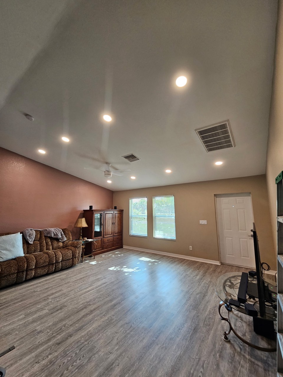Recessed lighting and a ceiling fan in a vaulted living room