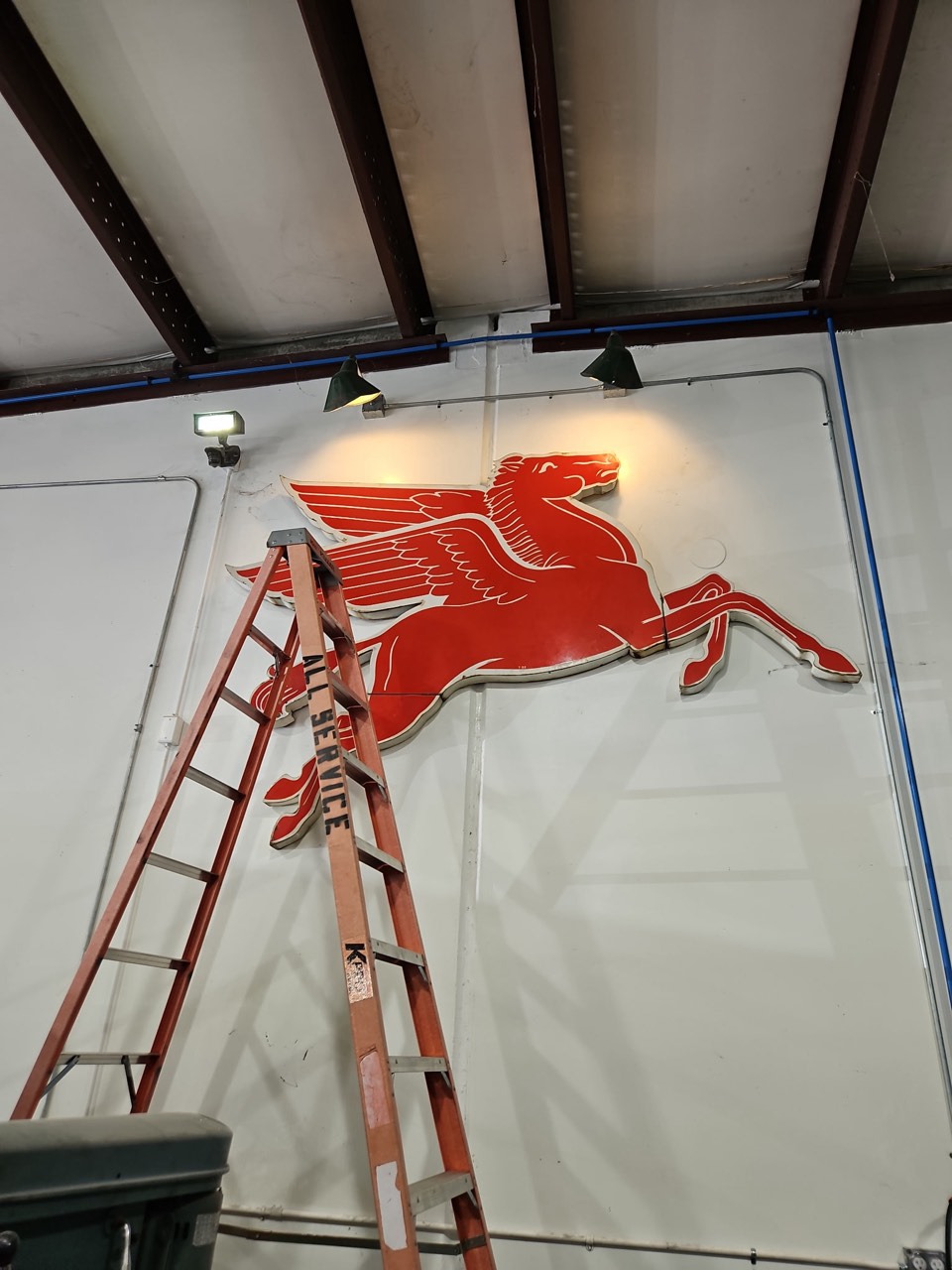 Large illuminated sign being mounted and lit on a wall